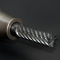High-quality close-up of a spiral drill bit showcasing metal textures on a black background.